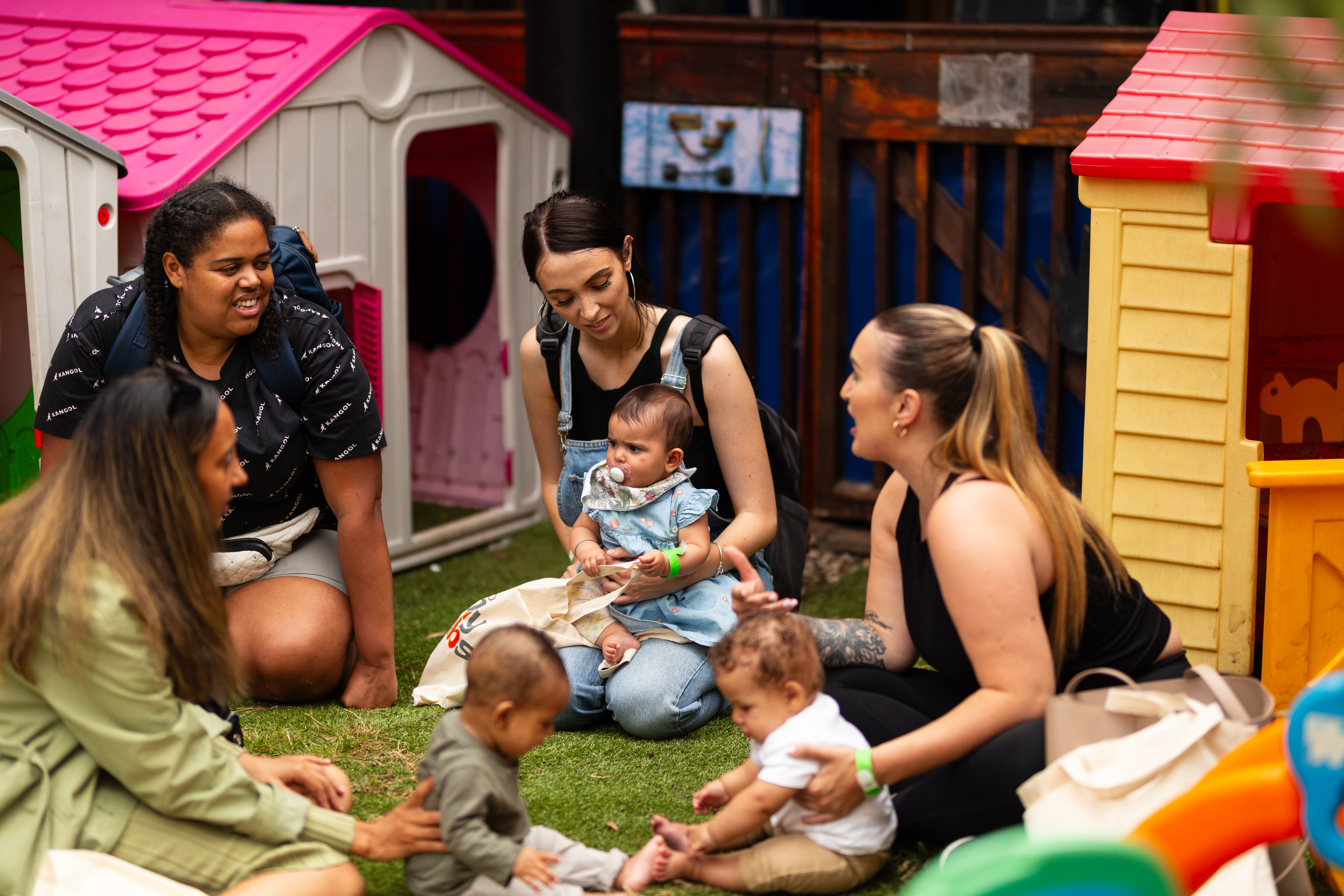 A group of mums playing with their babies together.