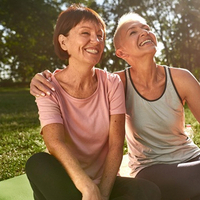 Two smiling women sitting on a picnic blanket