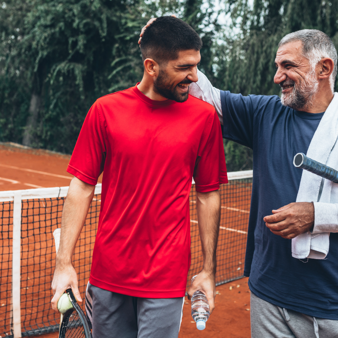 young man and older man play a game of tennis