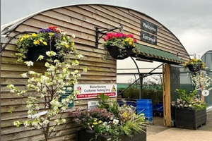 Exterior entrance of a garden centre. Domed greenhouse with plants outside.